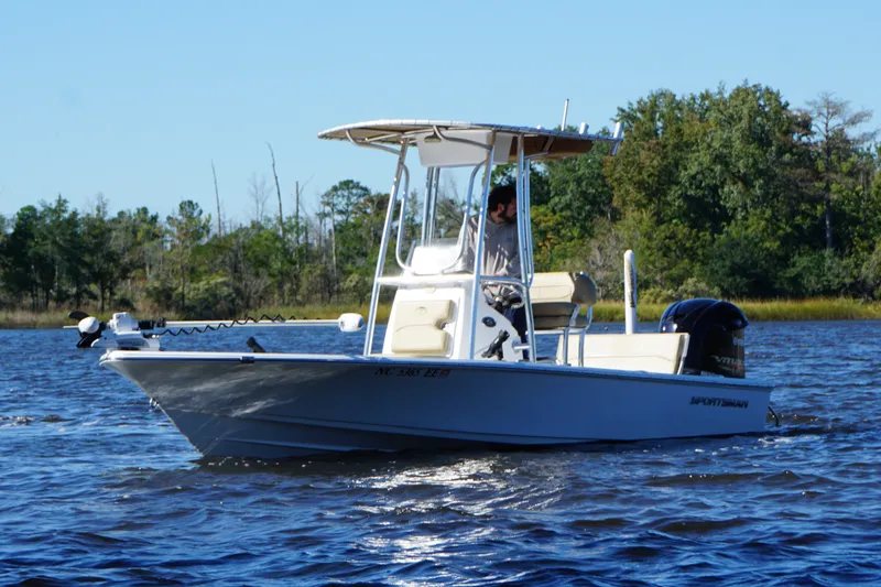 Slide: The Image of 2017 Sportsman Tournament 214 Bay Boat on calm water, surrounded by trees. - 26