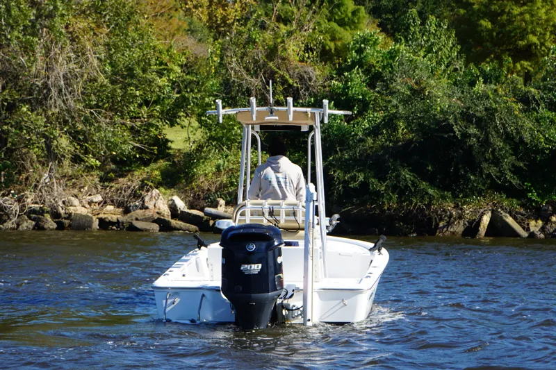 Slide: The Image of 2017 Sportsman Tournament 214 Bay Boat navigating a river with lush greenery. - 6
