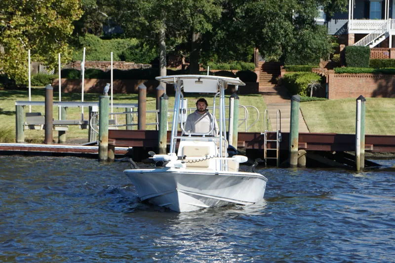 Slide: The Image of 2017 Sportsman Tournament 214 Bay Boat cruising near a dock with lush greenery. - 1