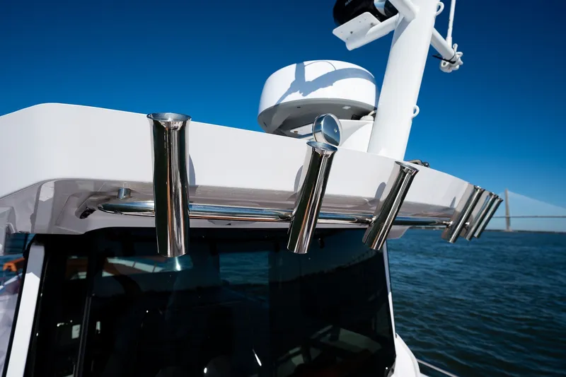 Slide: The Image of 2026 Axopar 29 XC Cross Cabin boat with stainless steel rod holders, ocean backdrop. - 16