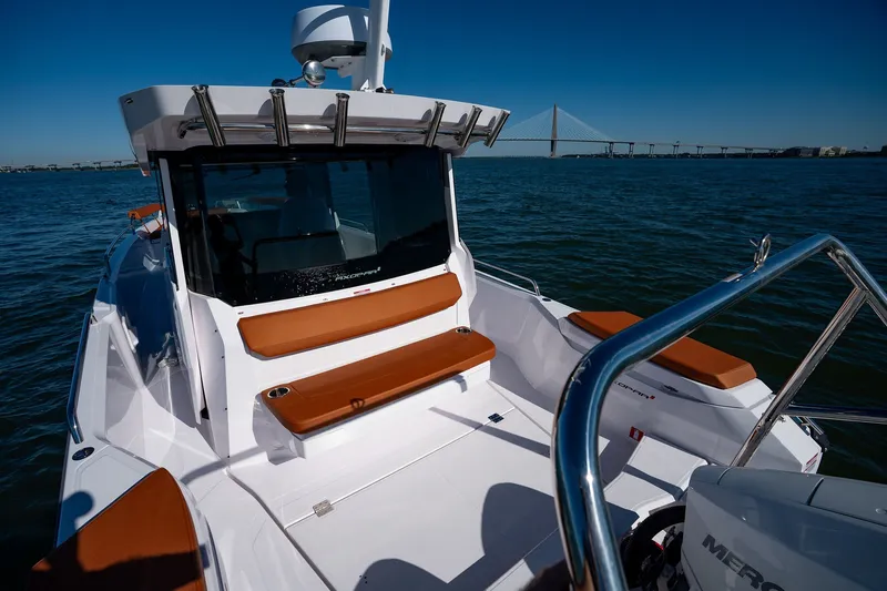 Slide: The Image of 2026 Axopar 29 XC Cross Cabin boat on water with bridge in background. - 15