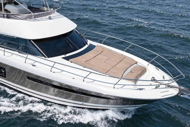 Slide: The Image of Luxurious 2014 Prestige 620 yacht cruising on open sea, featuring sleek design and spacious deck. - 5