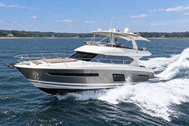 Slide: The Image of Luxury 2014 Prestige 620 yacht cruising on open water, clear skies, and scenic shoreline. - 2