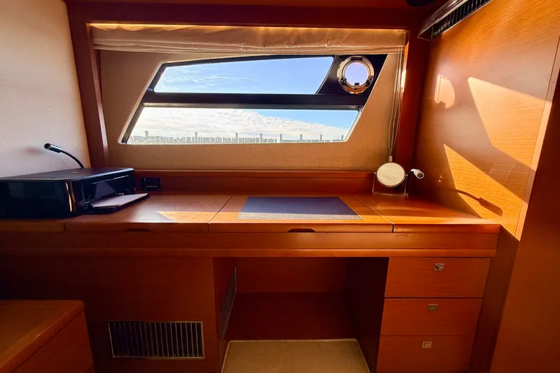 Slide: The Image of Luxurious wooden desk area inside a 2014 Prestige 620 yacht, featuring a window view. - 39