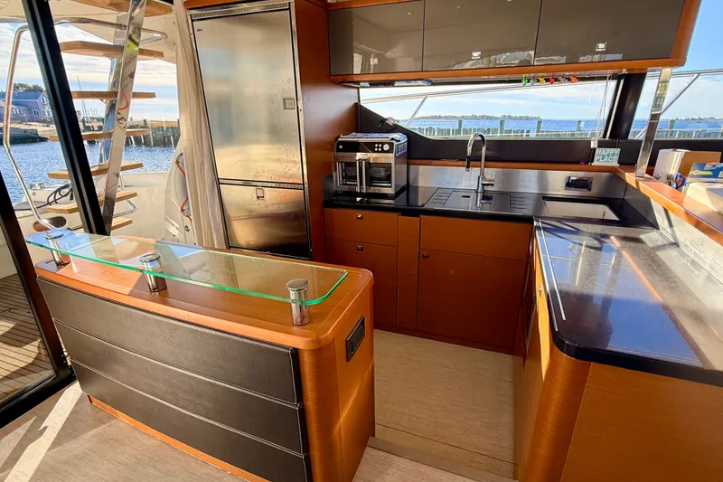 Slide: The Image of Luxurious 2014 Prestige 620 yacht kitchen with modern appliances and sleek wood finishes. - 21