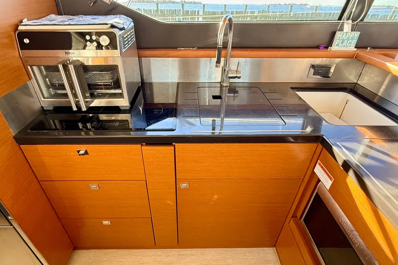 Slide: The Image of Modern kitchen in 2014 Prestige 620 yacht with sleek appliances and wood cabinetry. - 24