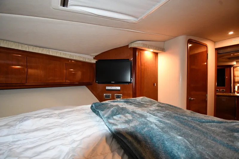 Slide: The Image of Luxurious cabin interior of 2005 Sea Ray 420 Sundancer yacht with TV and wood paneling. - 24