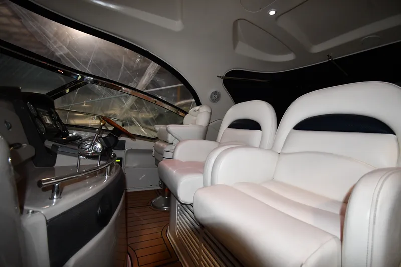 Slide: The Image of Interior of 2005 Sea Ray 420 Sundancer yacht with luxurious white seating and helm controls. - 11