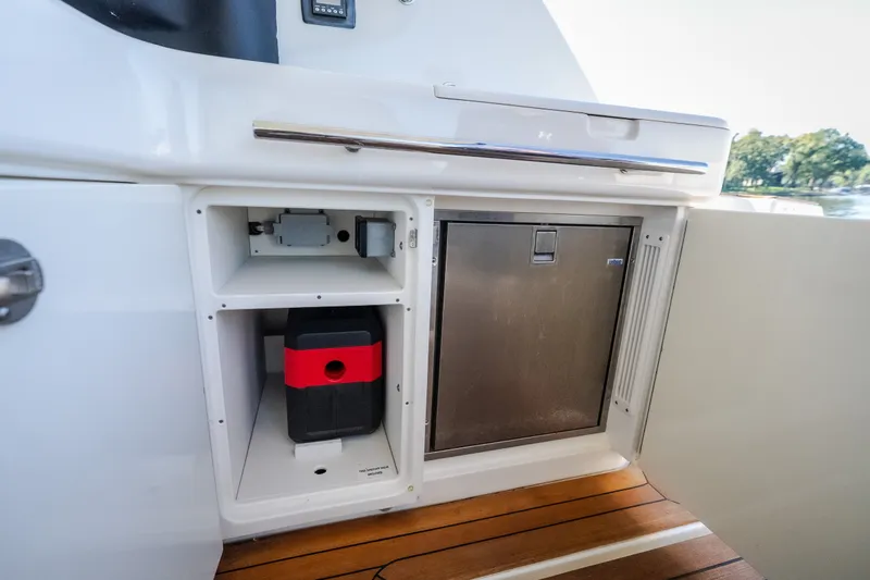 Slide: The Image of 2012 Sea Ray 450 Sundancer yacht interior with storage compartments and stainless steel fridge. - 59