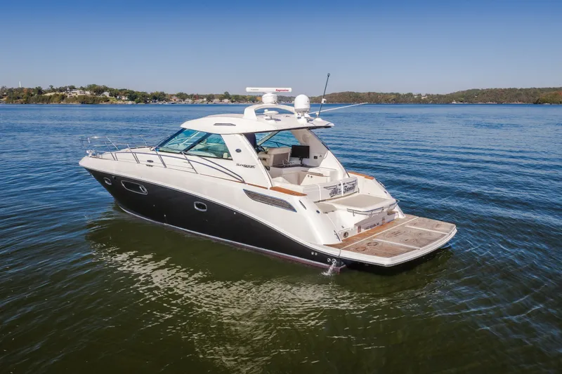 Slide: The Image of 2012 Sea Ray 450 Sundancer yacht cruising on a calm lake under clear skies. - 7