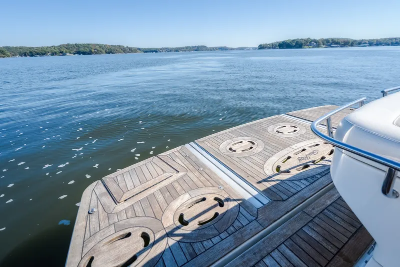 Slide: The Image of 2012 Sea Ray 450 Sundancer yacht deck overlooking serene lake waters. - 11