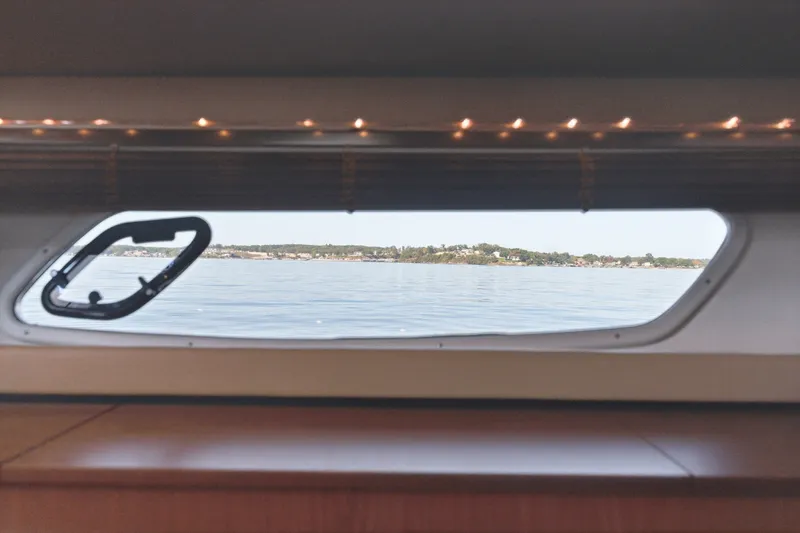 Slide: The Image of View from a 2012 Sea Ray 450 Sundancer window overlooking calm waters and distant shoreline. - 40