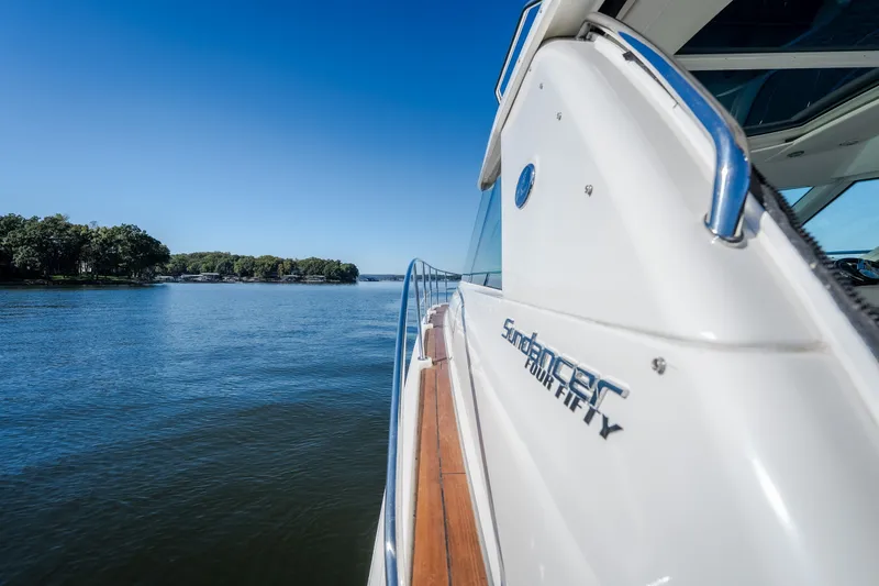 Slide: The Image of 2012 Sea Ray 450 Sundancer yacht cruising on a serene lake under clear blue skies. - 46