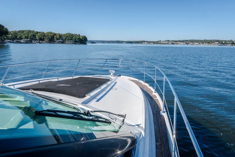 Slide: The Image of 2012 Sea Ray 450 Sundancer cruising on a serene lake under clear blue skies. - 53