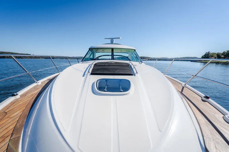 Slide: The Image of 2012 Sea Ray 450 Sundancer yacht on calm water, showcasing sleek design and spacious deck. - 49