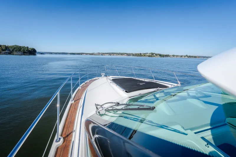 Slide: The Image of 2012 Sea Ray 450 Sundancer cruising on a serene lake under clear blue skies. - 47