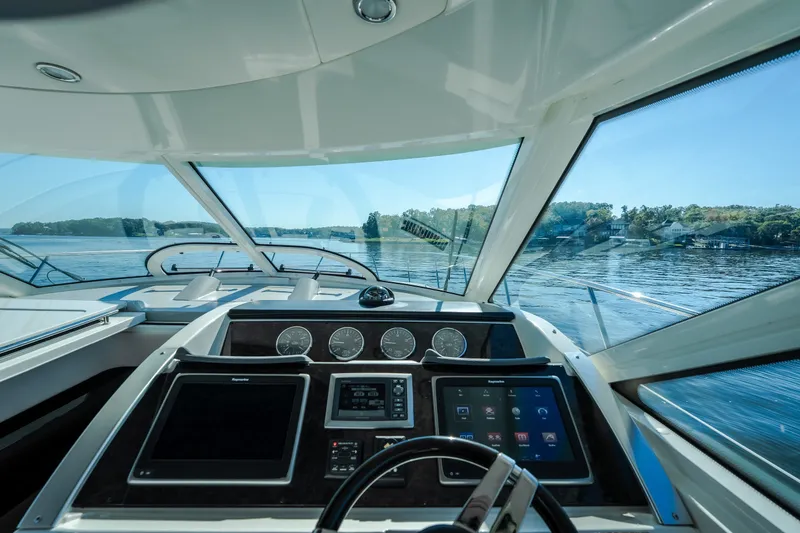 Slide: The Image of Cockpit view of 2012 Sea Ray 450 Sundancer yacht on a serene lake. - 26