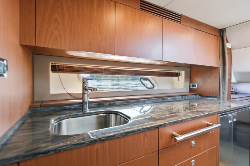 Slide: The Image of Luxurious kitchen interior of 2012 Sea Ray 450 Sundancer yacht with wood cabinetry. - 44