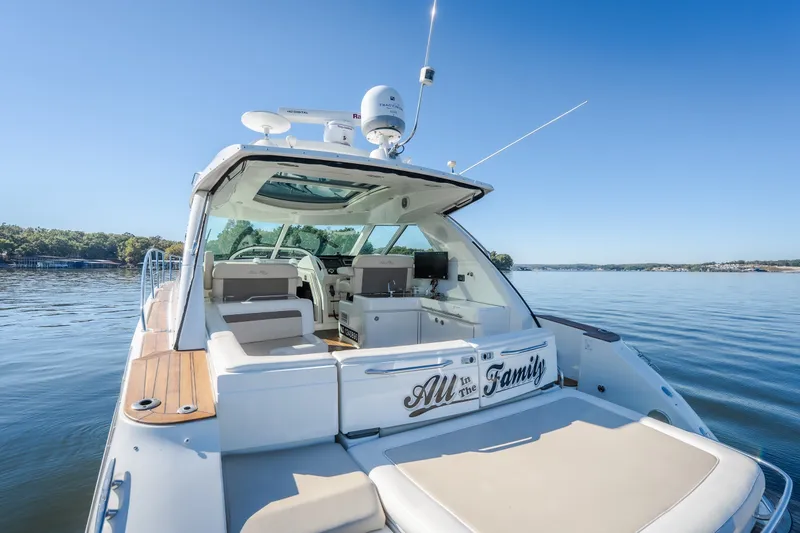 Slide: The Image of 2012 Sea Ray 450 Sundancer yacht on calm water, featuring spacious deck and luxurious seating. - 16