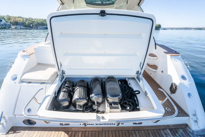 Slide: The Image of Open storage compartment on 2012 Sea Ray 450 Sundancer yacht, containing black fenders and ropes. - 12