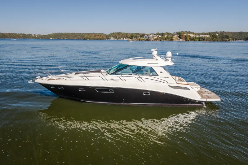 Slide: The Image of 2012 Sea Ray 450 Sundancer yacht cruising on a calm lake under clear skies. - 5