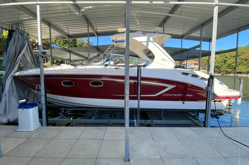 The Image of 2012 Chaparral 327 SSX boat docked under a covered marina. - 1