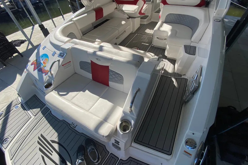 Slide: The Image of 2012 Chaparral 327 SSX boat interior with white and red seating, docked at marina. - 21