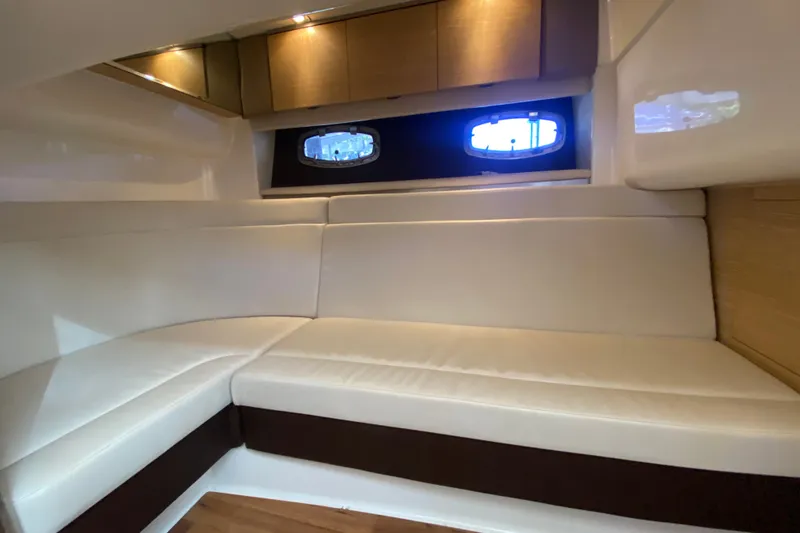 Slide: The Image of Interior of 2012 Chaparral 327 SSX boat with white seating and wooden cabinets. - 41