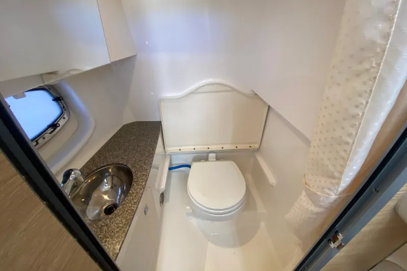 Slide: The Image of 2012 Chaparral 327 SSX boat bathroom with sink, toilet, and window. - 42
