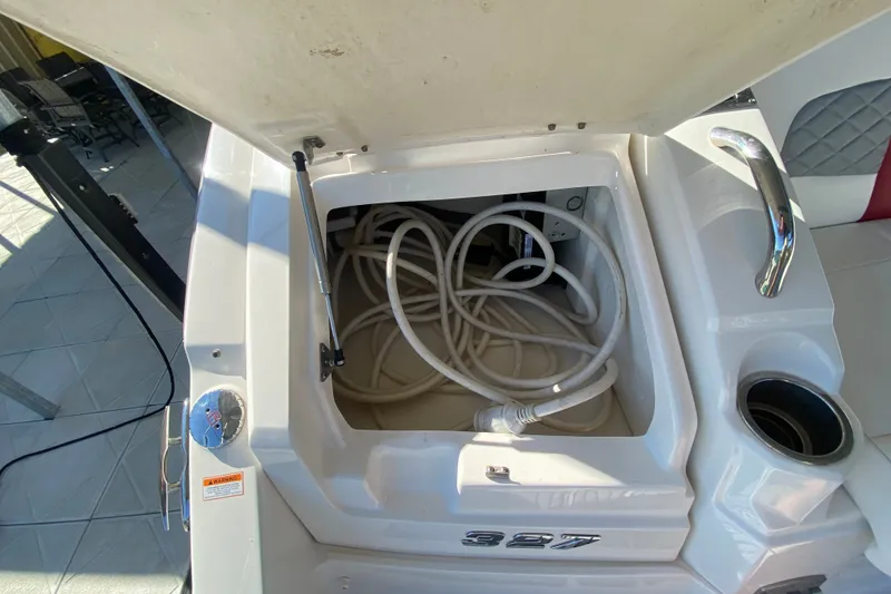 Slide: The Image of Open storage compartment on 2012 Chaparral 327 SSX boat with coiled hose inside. - 20