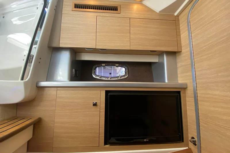 Slide: The Image of Interior of 2012 Chaparral 327 SSX boat with wood cabinetry and a small window. - 40