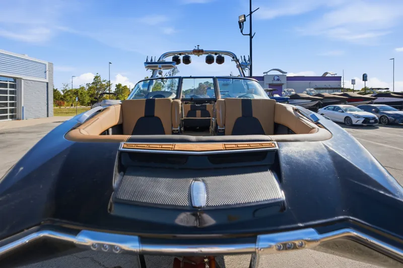 Slide: The Image of 2020 MasterCraft X24 boat with tan interior, parked outdoors under a clear blue sky. - 14