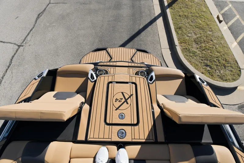 Slide: The Image of 2020 MasterCraft X24 boat interior with tan seating and deck, viewed from above. - 43