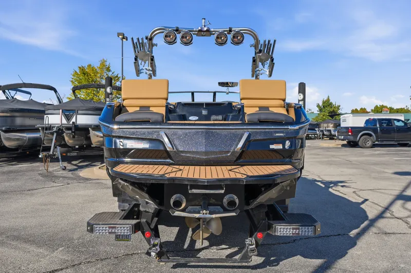 Slide: The Image of 2020 MasterCraft X24 boat with tan seats and sleek design in a marina setting. - 45