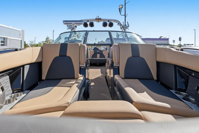 Slide: The Image of 2020 MasterCraft X24 boat interior with tan and black seating, showcasing luxury and comfort. - 33