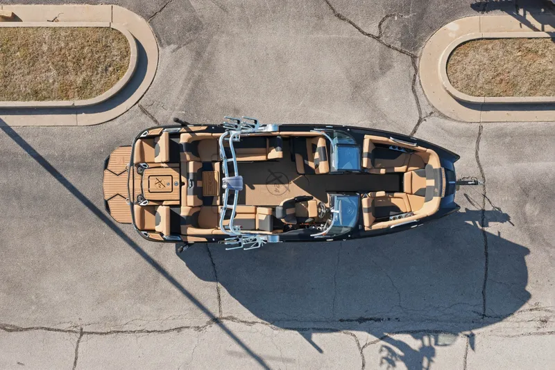 Slide: The Image of 2020 MasterCraft X24 boat, aerial view, parked on pavement, showcasing seating and layout. - 46