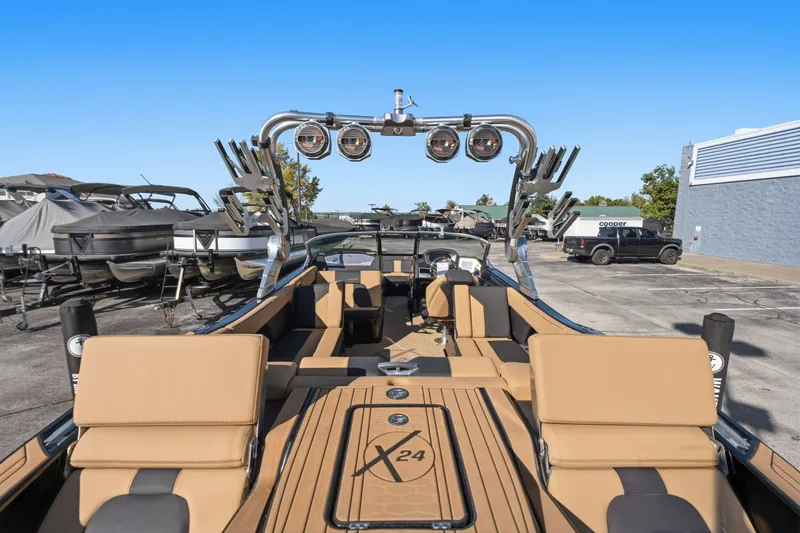 Slide: The Image of 2020 MasterCraft X24 boat with tan seating and sleek design in a marina setting. - 21