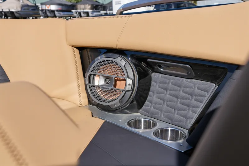 Slide: The Image of 2020 MasterCraft X24 interior with speaker, cup holders, and tan upholstery. - 31