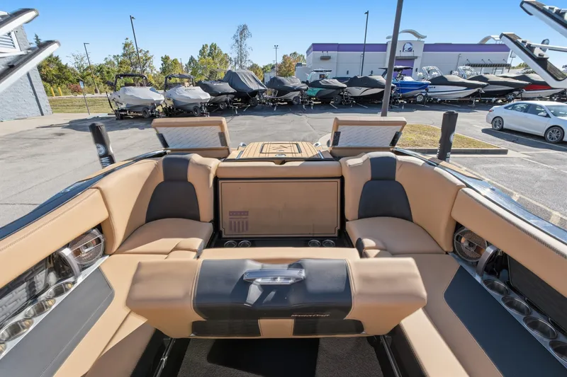 Slide: The Image of 2020 MasterCraft X24 boat interior with tan seating, parked in a marina. - 37