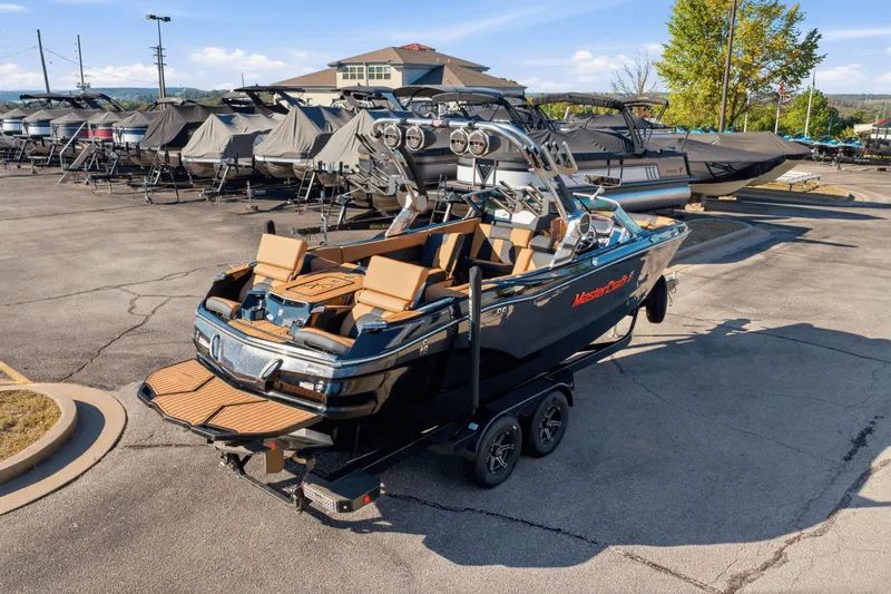 Slide: The Image of 2020 MasterCraft X24 boat on trailer in marina parking lot. - 17