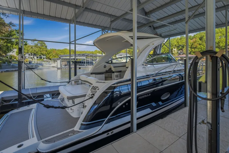 Slide: The Image of 2017 Formula 37 Performance Cruiser docked in a covered marina, surrounded by scenic water views. - 66