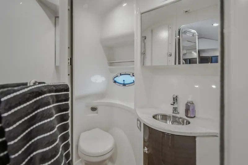 Slide: The Image of 2017 Formula 37 Performance Cruiser bathroom with sink, toilet, mirror, and porthole window. - 50