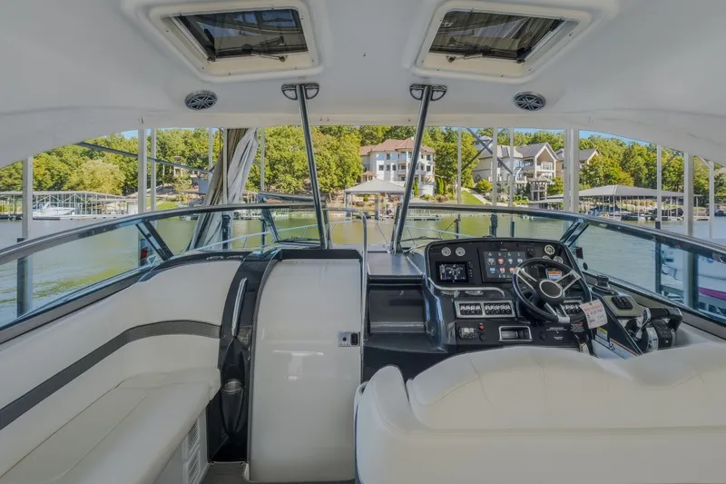 Slide: The Image of 2017 Formula 37 Performance Cruiser helm with modern controls, docked near waterfront homes. - 23