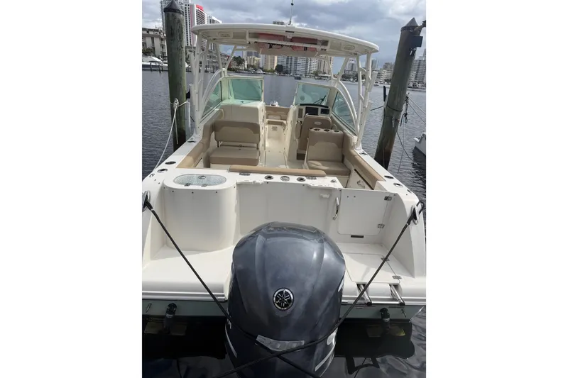 Slide: The Image of 2019 Sailfish 245 DC boat docked, featuring spacious seating and powerful outboard motor. - 6