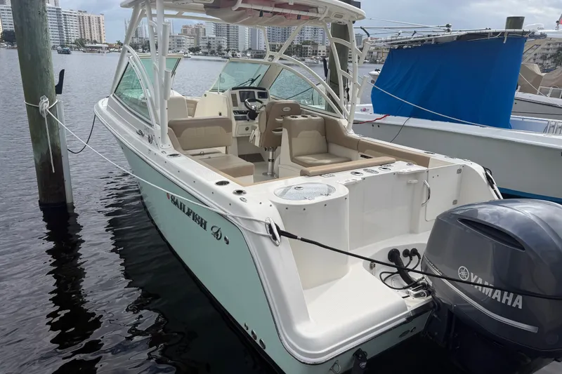 Slide: The Image of 2019 Sailfish 245 DC boat docked with Yamaha outboard motor, cityscape in background. - 4