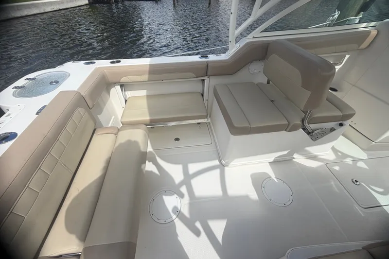 Slide: The Image of 2019 Sailfish 245 DC boat interior with beige seating and water view. - 35