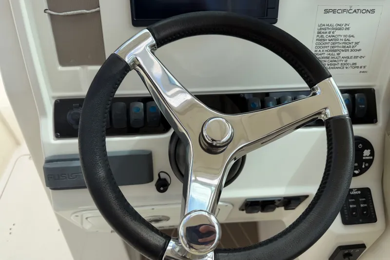 Slide: The Image of Steering wheel of 2019 Sailfish 245 DC boat with control panel and specifications. - 17