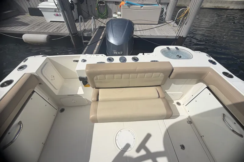 Slide: The Image of 2019 Sailfish 245 DC boat interior with seating and outboard motor at dock. - 30