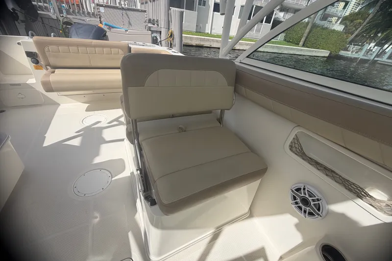 Slide: The Image of 2019 Sailfish 245 DC boat interior with beige seating and speaker. - 28