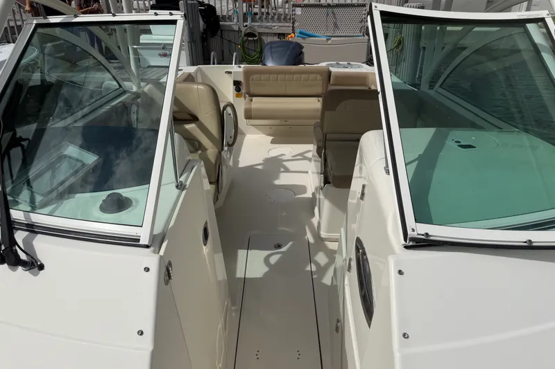 Slide: The Image of 2019 Sailfish 245 DC boat interior with beige seating and dual consoles. - 12